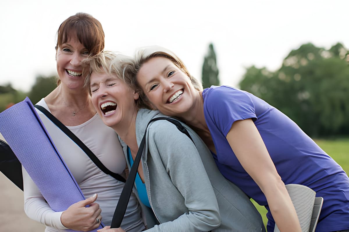 Smiling women holding yoga mats